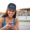 Bitney Adventures Organic Baseball Cap With Logo - Girl on Cell Phone Outside Wearing Cap - Pacific